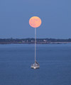 The Full Moon atop a boat mast